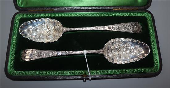 A cased matched pair of later-embossed George III silver berry spoons, London, 1796, one by Peter & Ann Bateman.